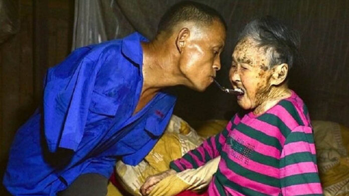 Men feed a elderly women